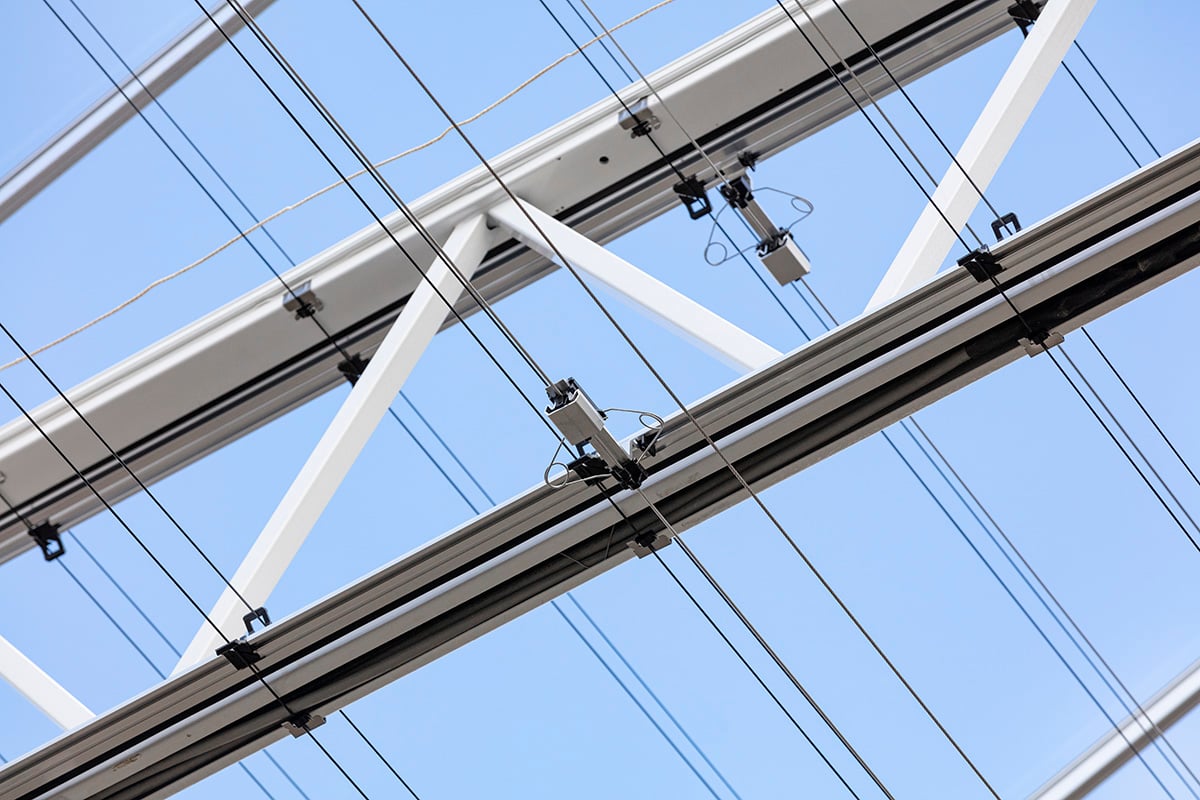 Een bovengrondse elektriciteitsinfrastructuur met meerdere dwarsbalken en elektriciteitsleidingen tegen een strakblauwe lucht.