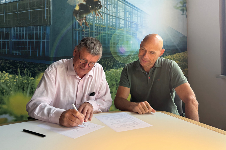 Twee mannen ondertekenen een overeenkomst aan een tafel