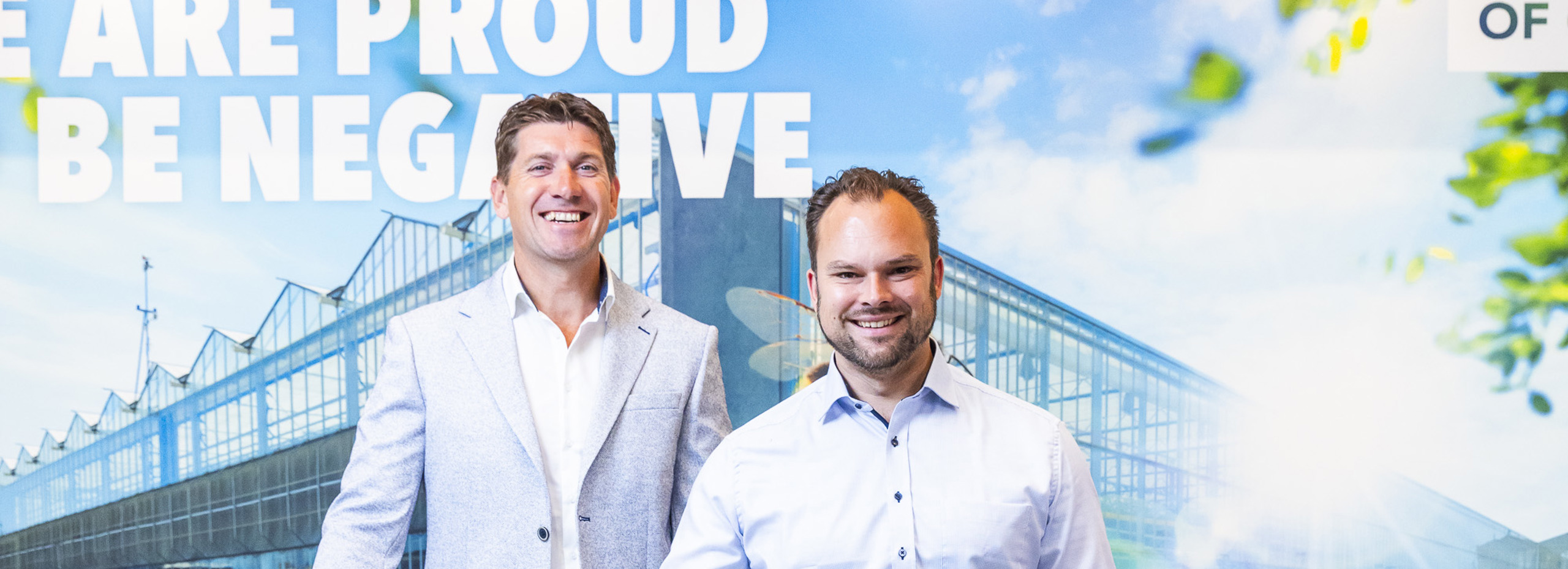 Twee mensen staan voor een beursstand.