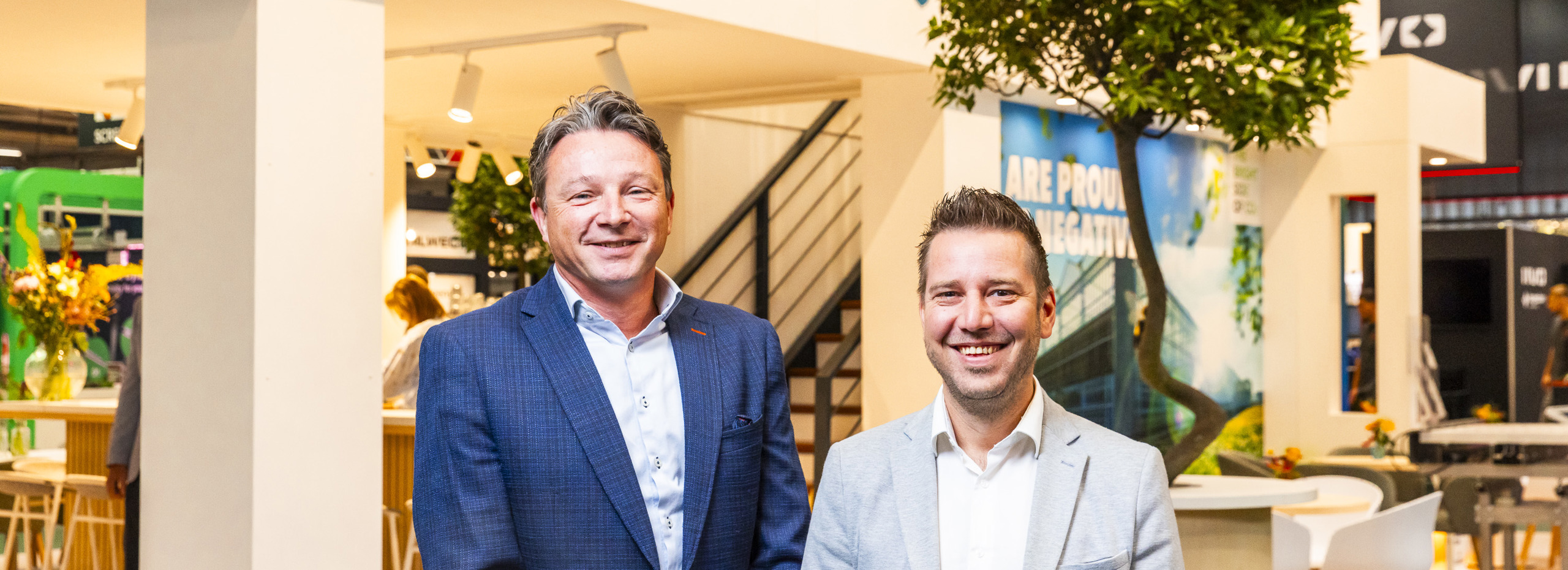 Groep met mensen staan voor een beursstand.
